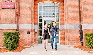 Caitlin and Joe hold hands while walking in front of Woodward Hall.