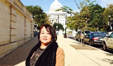 My Lan Tran stands o a sidewalk in front of the U.S. Capitol.